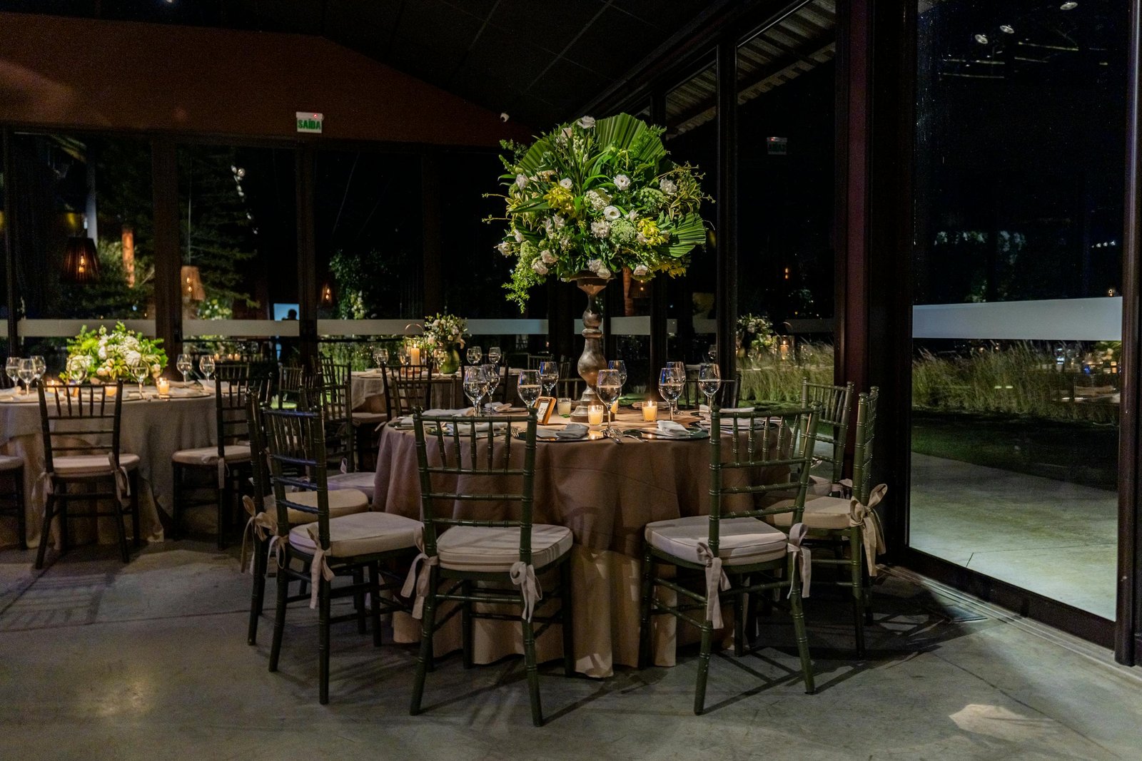 Luxurious indoor dining scene with floral decorations and elegant table settings.
